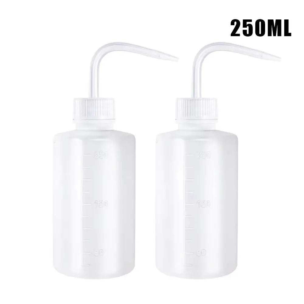 Two clear plastic squeeze bottles with precision tips for tattoo ink or liquid application