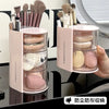 A pink clear acrylic organizer for hair brushes and accessories with rotating compartments.