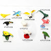 A collection of realistic animal figurines including a yellow bird, blue and yellow bird, white bird, green bird, and pink fl