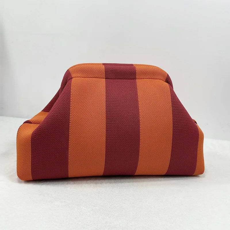 Bolso de crochet tejido a rayas naranja y granate visto de lado.
