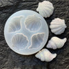 A set of white shell and starfish fondant molds for cake decorating, showing various shapes.