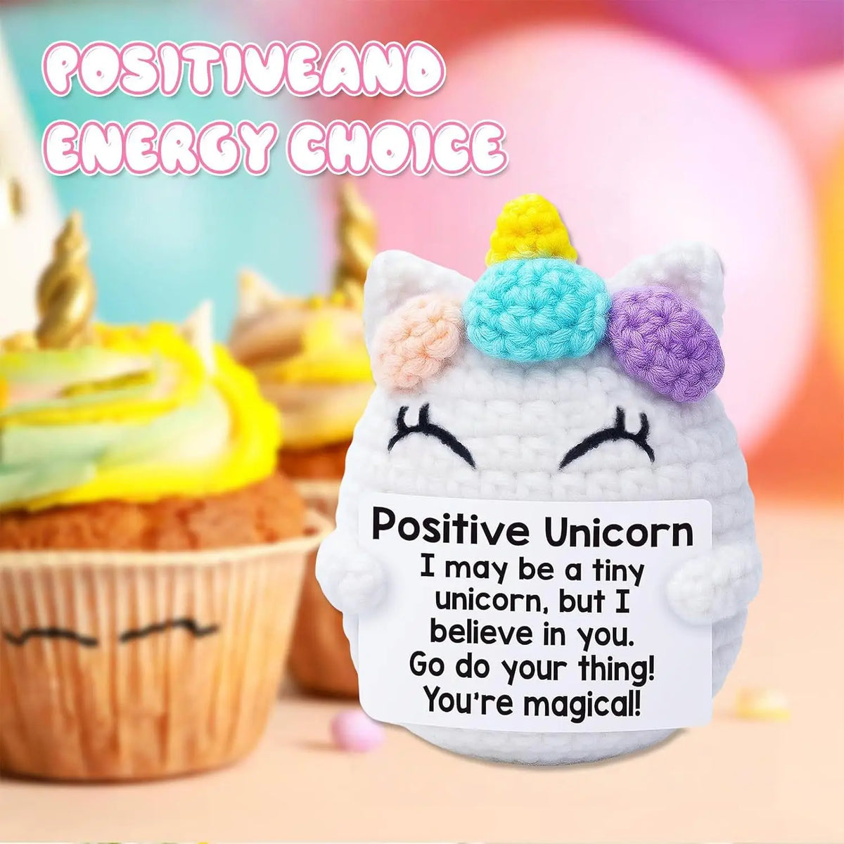 A white crocheted unicorn doll with colorful ears sitting next to a cupcake, featuring positive encouragement text.
