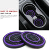 A set of two purple and black non-slip silicone car cup holder coasters shown next to a close-up view of the product inside a