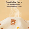 A close-up of a white soft cotton gauze baby swaddle blanket with a brown bear design, shown against a light background.