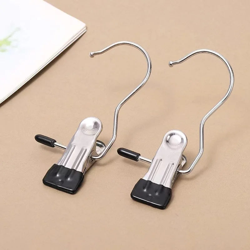 A pair of stainless steel clothespins with hooks used as a space-saving closet organizer.