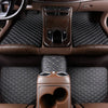 Interior view of a car showing premium PU leather floor mats and dark brown upholstery.