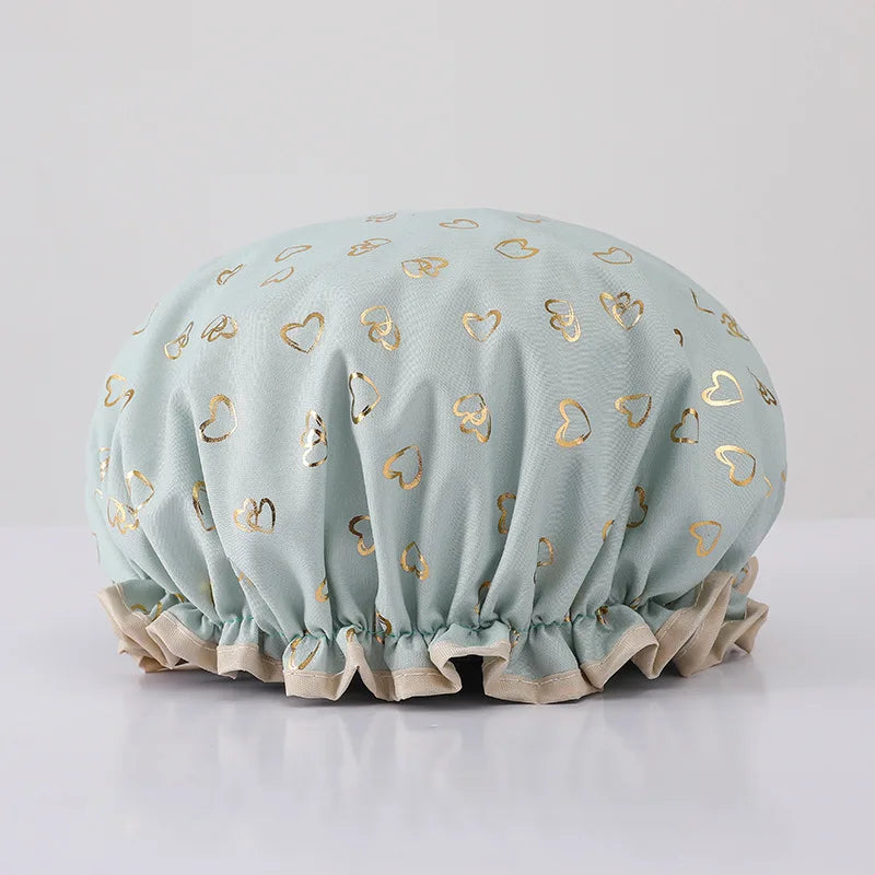 Light blue reusable elastic shower cap decorated with gold heart patterns