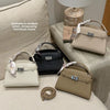 Eine Sammlung eleganter PU-Leder-Clutch-Taschen in verschiedenen neutralen Tönen auf einer hellen Stoffoberfläche.