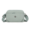 A light sage green nylon crossbody bag with a flap and adjustable strap is shown against a white background.