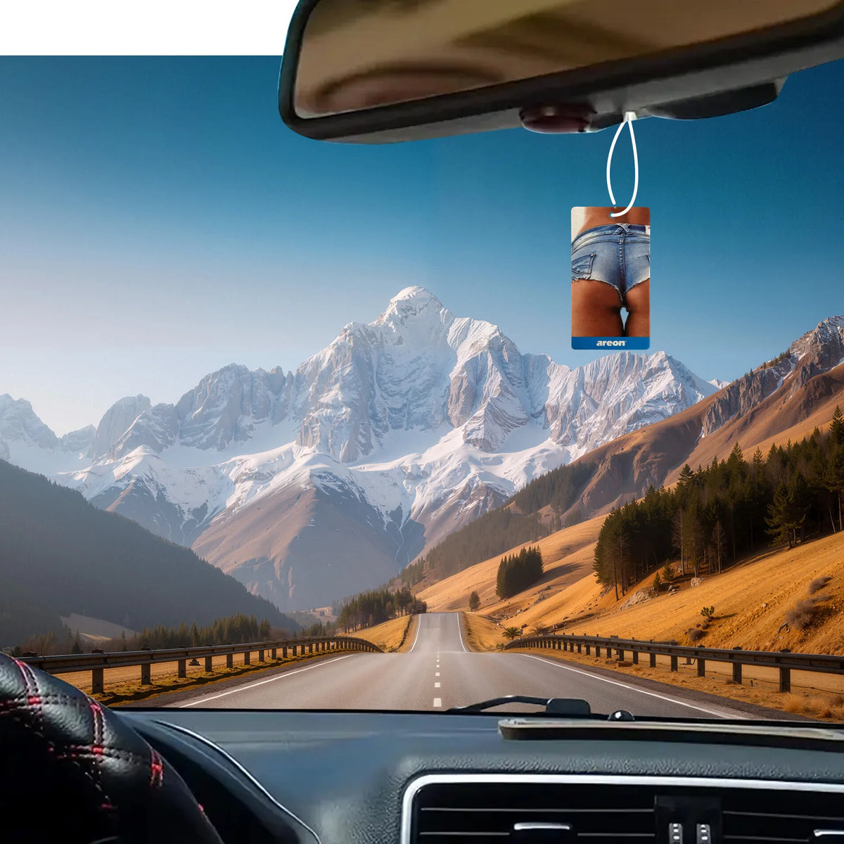 A hanging car air freshener with assorted scents is visible inside a car cabin, viewed through the windshield.