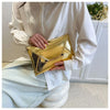 A person holds a gold crocodile pattern PU envelope clutch with a coin pocket against a white background.