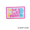 Pink embroidered patch with the letters WWJD and the text WOULD LOVE FIRST in yellow and blue thread.