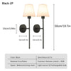 A set of two black LED wall sconces with fabric shades and remote control features.