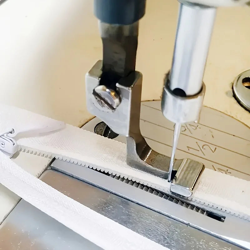 Stainless steel invisible zipper presser foot attached to a sewing machine needle plate.