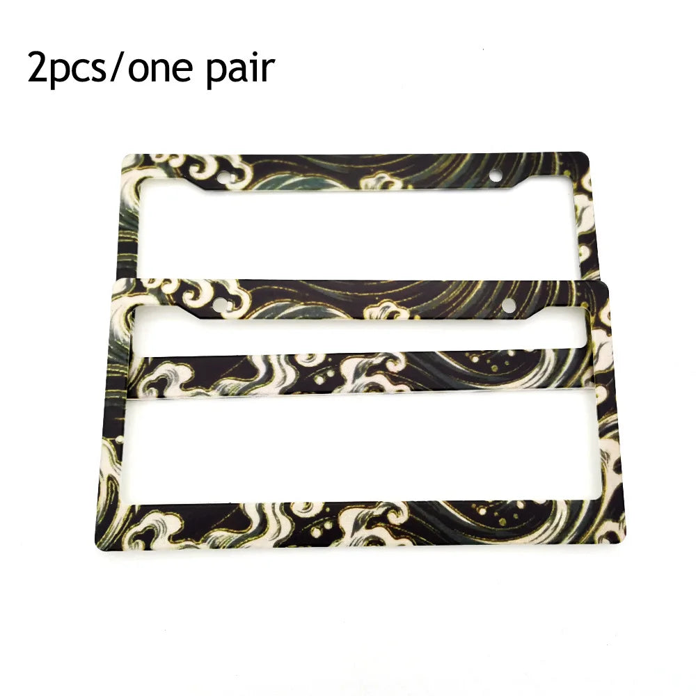 Two racing style license plate frames with a marbled black and gold pattern.