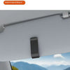 A close-up view of a black clip-on mounting system for holding glasses on a car window.
