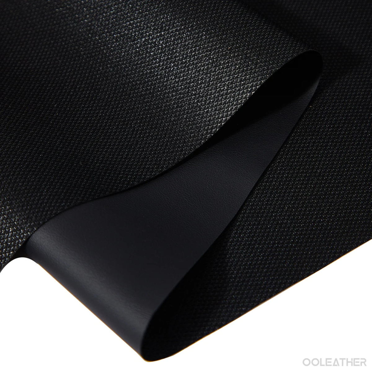 Black self-adhesive faux leather sheets rolled and displayed on a surface.