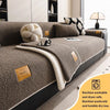 A cozy anti-slip lamb fleece sofa mat in beige and gray is shown on a dark sofa.