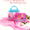 A pink butterfly bag makeup set with a clear case and various cosmetic items displayed on a pink silk fabric.