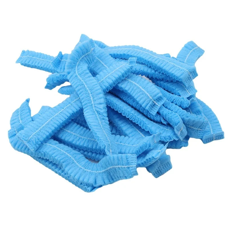 A pile of light blue disposable non-woven hair net caps.