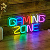 A neon sign spelling out GAMING ZONE glowing in various bright colors on a wooden surface.