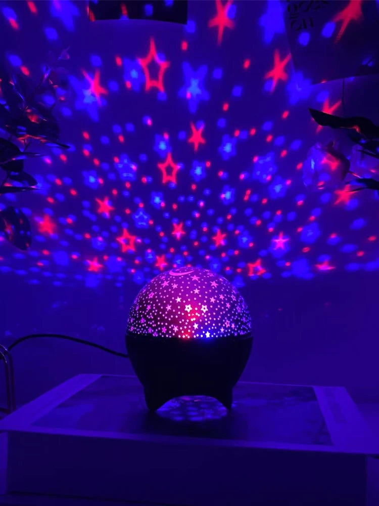 A purple LED projector casts a starry sky pattern onto the ceiling, illuminating a dark room.