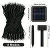 A bundle of black solar powered outdoor string lights with a rectangular panel and a separate light head.