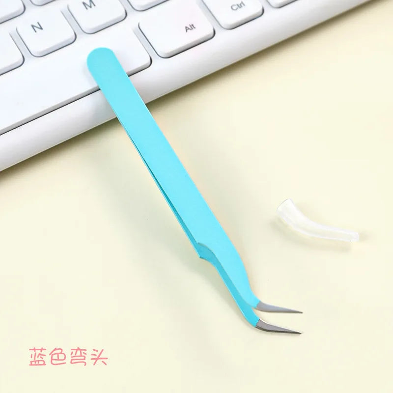 A light blue precision craft tool featuring straight and curved tips resting on a white keyboard.