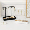 Elegant jewelry display rack with a black drawer and a white stand for hanging necklaces.