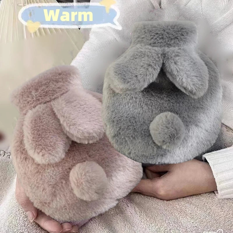 A soft pink plush rabbit hot water bottle with a gray flannel cover being held in a person's hands.