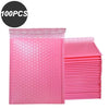 A stack of 100 pink bubble mailers used for padded self-seal shipping envelopes.