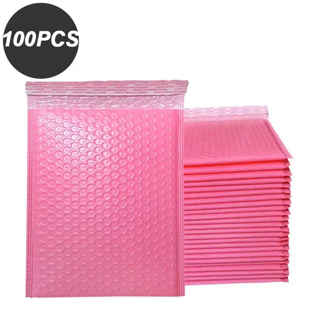 A stack of 100 pink bubble mailers used for padded self-seal shipping envelopes.