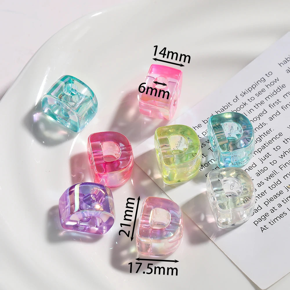 A collection of colorful acrylic alphabet beads in various shades and sizes displayed on a white plate.