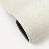 A close-up view of a thick, off-white plush non-slip rug or mat with a black edge.
