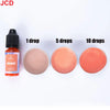 A set of orange liquid candle dye in dropper bottles and various amounts of colored liquid for DIY candle making
