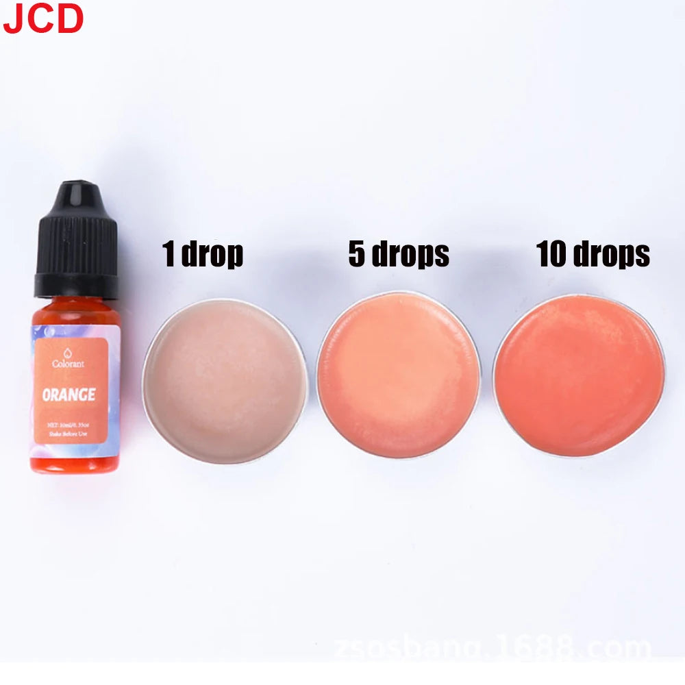 A set of orange liquid candle dye in dropper bottles and various amounts of colored liquid for DIY candle making