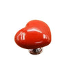 A glossy orange heart-shaped toilet flush button with a nail protector.