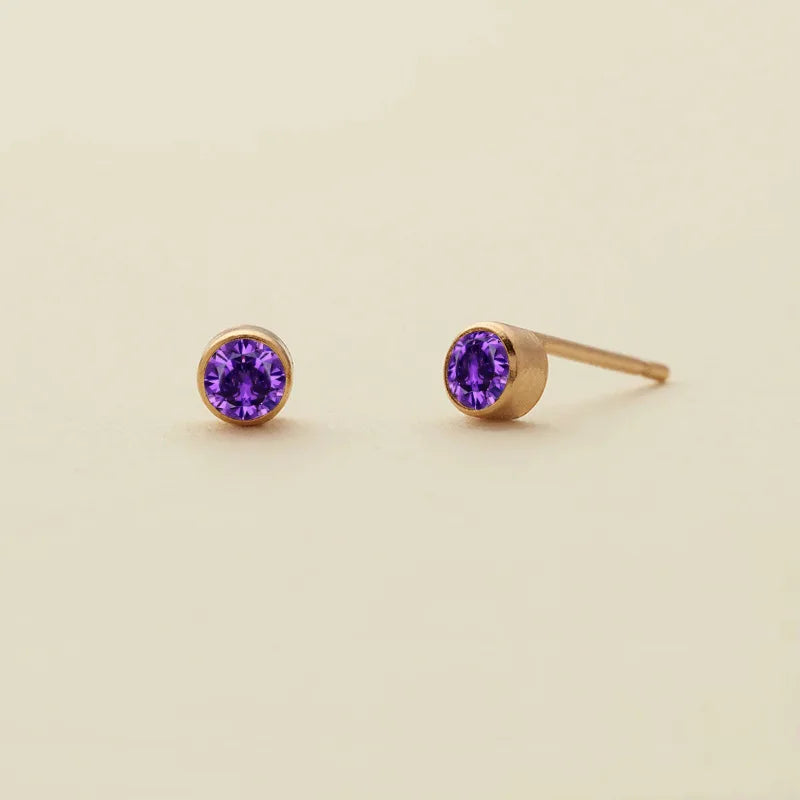 Boucles d'oreilles à clous minimalistes en pierre de naissance violet profond sur socles dorés.