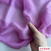 Close-up of light purple silk chiffon fabric draped and held by a hand