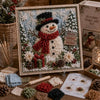 A framed piece of 3D fabric poke art depicting a woman made of white and red fabric with a black hat and scarf.