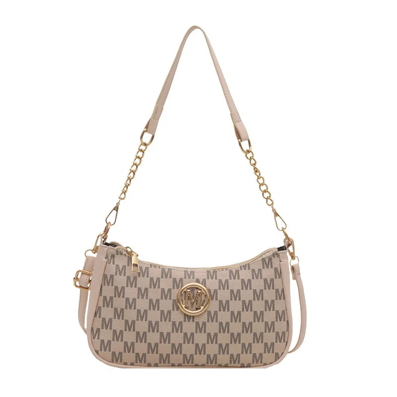 A beige PU leather crossbody bag with a gold chain strap and a metal 'M' accent on the front.