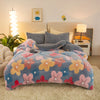 A cozy bedroom scene featuring a light blue plush throw blanket draped over a bed and a fluffy rug.