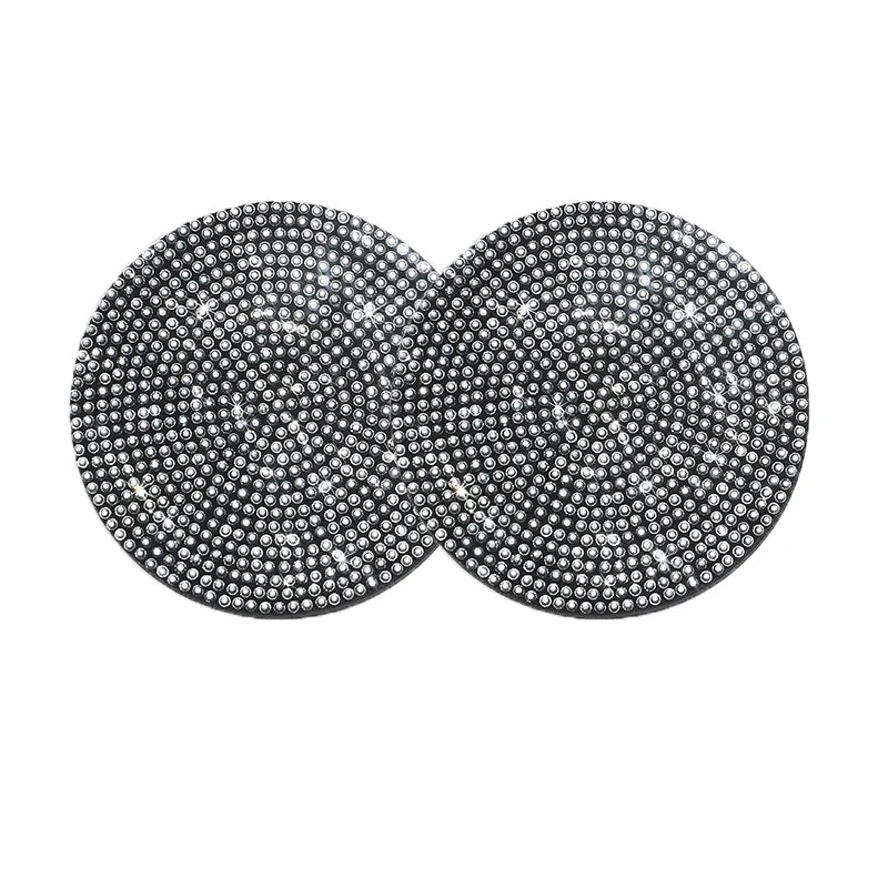 A set of two round, silver-toned diamond-encrusted non-slip coasters.