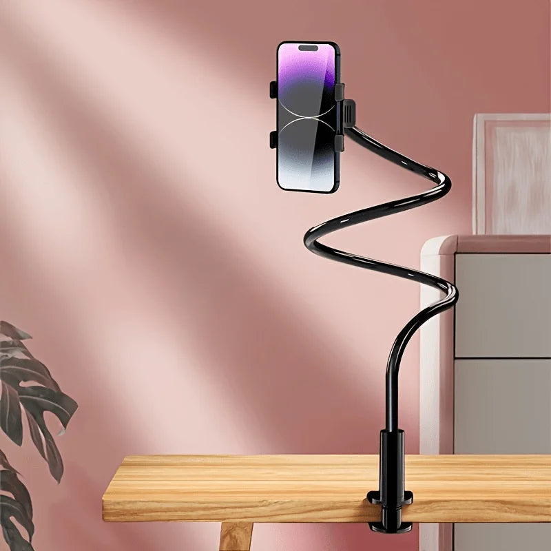 A black flexible stand holding a smartphone in a vertical position on a wooden desk.