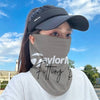 A person wearing a gray multifunctional neck gaiter or face cover outdoors under a blue sky.
