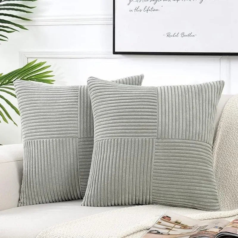 A set of two gray corduroy patchwork throw pillow covers with vertical ribbed texture.