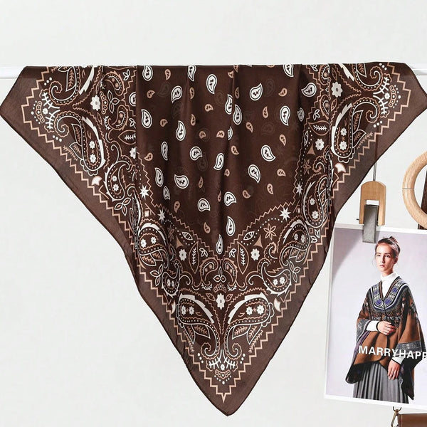 A dark brown scarf featuring intricate white paisley and bohemian patterns.