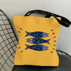 A yellow canvas tote bag featuring a repeating pattern of blue and purple fish prints.