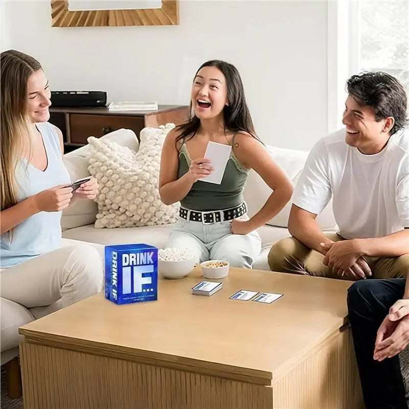 Three adults laughing while playing a drinking game with cards on a table