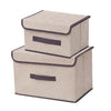 A set of two beige fabric storage boxes with dark trim for closet and drawer organization.